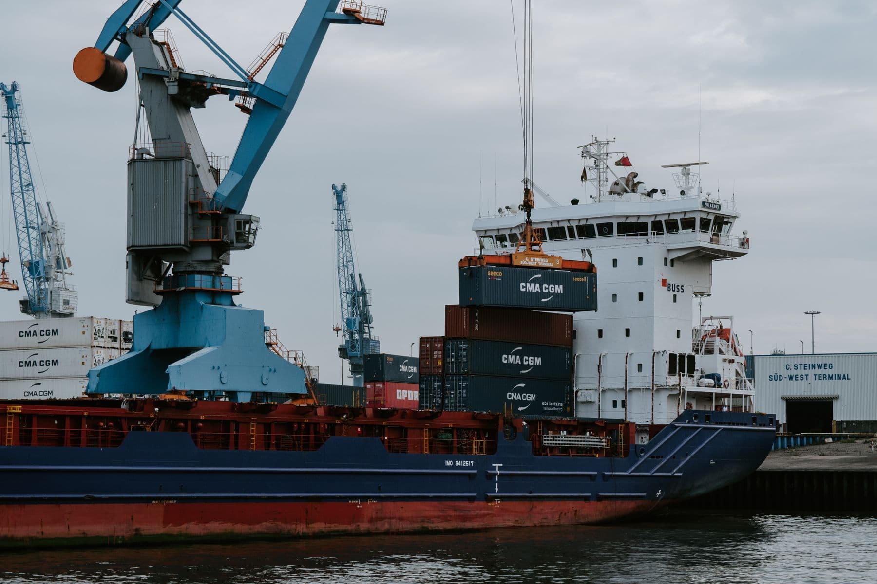 A bulk ship and crane at an industrial harbor.